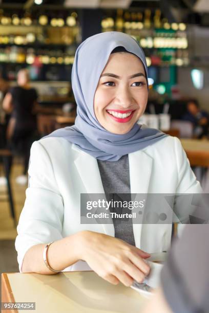 young asian couple enjoying lunch and coffee together - malaysian culture stock pictures, royalty-free photos & images