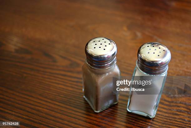 salt, pepper, a wood table and copy space - pepper pot stock pictures, royalty-free photos & images