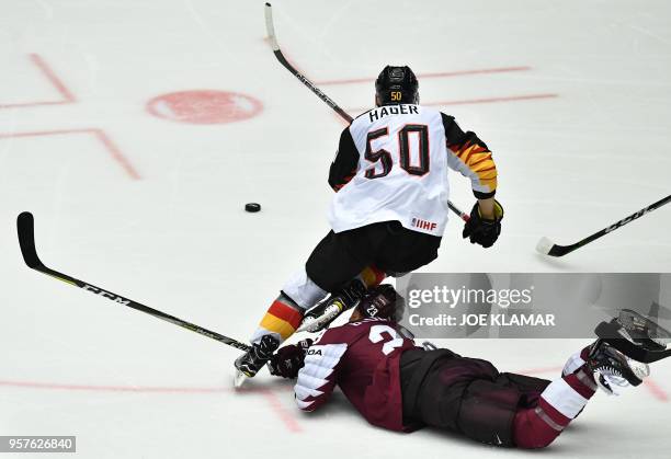 Latvia's Teodors Blugers and Germany's Patrick Hager challenge for the puck during the group B match Latvia vs Germany of the 2018 IIHF Ice Hockey...