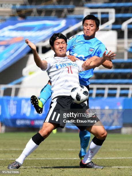 Ryo Tadokoro of Yokohama FC and Yusuke Minagawa of Roasso Kumamoto compete for the ball during the J.League J2 match between Yokohama FC and Roasso...