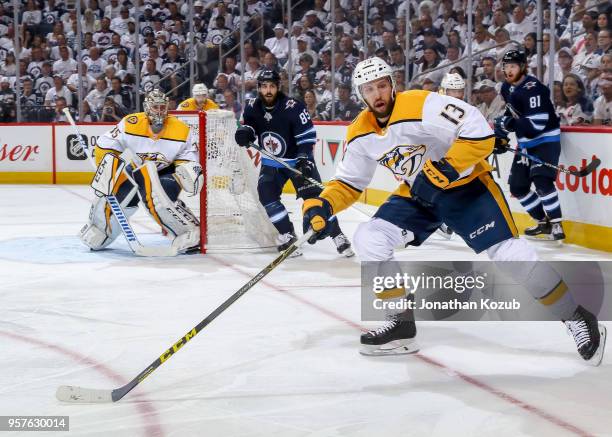 Goaltender Pekka Rinne, Nick Bonino of the Nashville Predators and Mathieu Perreault of the Winnipeg Jets keep an eye on the play along the boards...