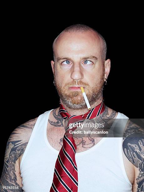 tattooed man with crossed eyes, cigarette and tie. - cross eyed 個照片及圖片檔
