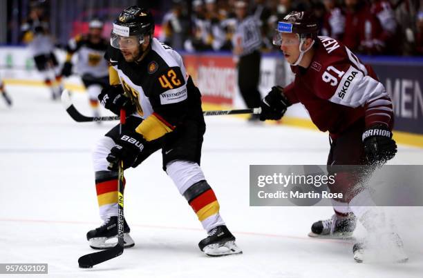 Ronalds Kenins of Latvia and Yasin Ehliz of Germany battle for the puck during the 2018 IIHF Ice Hockey World Championship Group B game between...