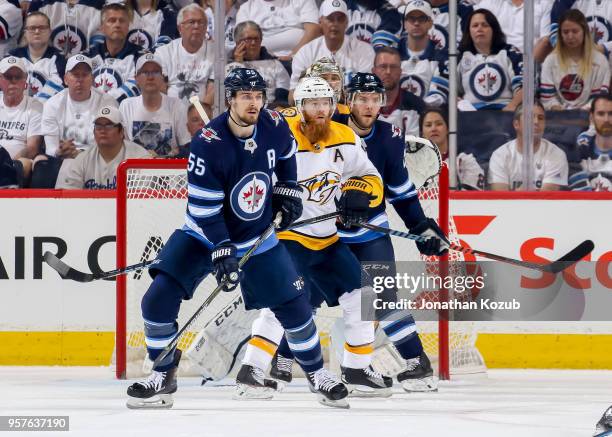 Ryan Ellis of the Nashville Predators stands between Mark Scheifele and Paul Stastny of the Winnipeg Jets as they keep an eye on the play during...