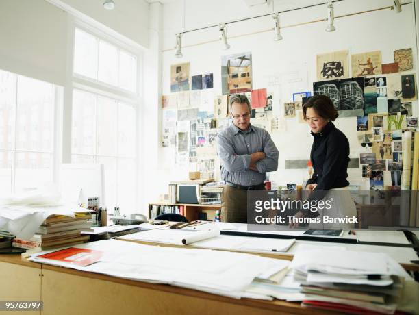 two colleagues discussing plans at desk - leanintogether stock pictures, royalty-free photos & images
