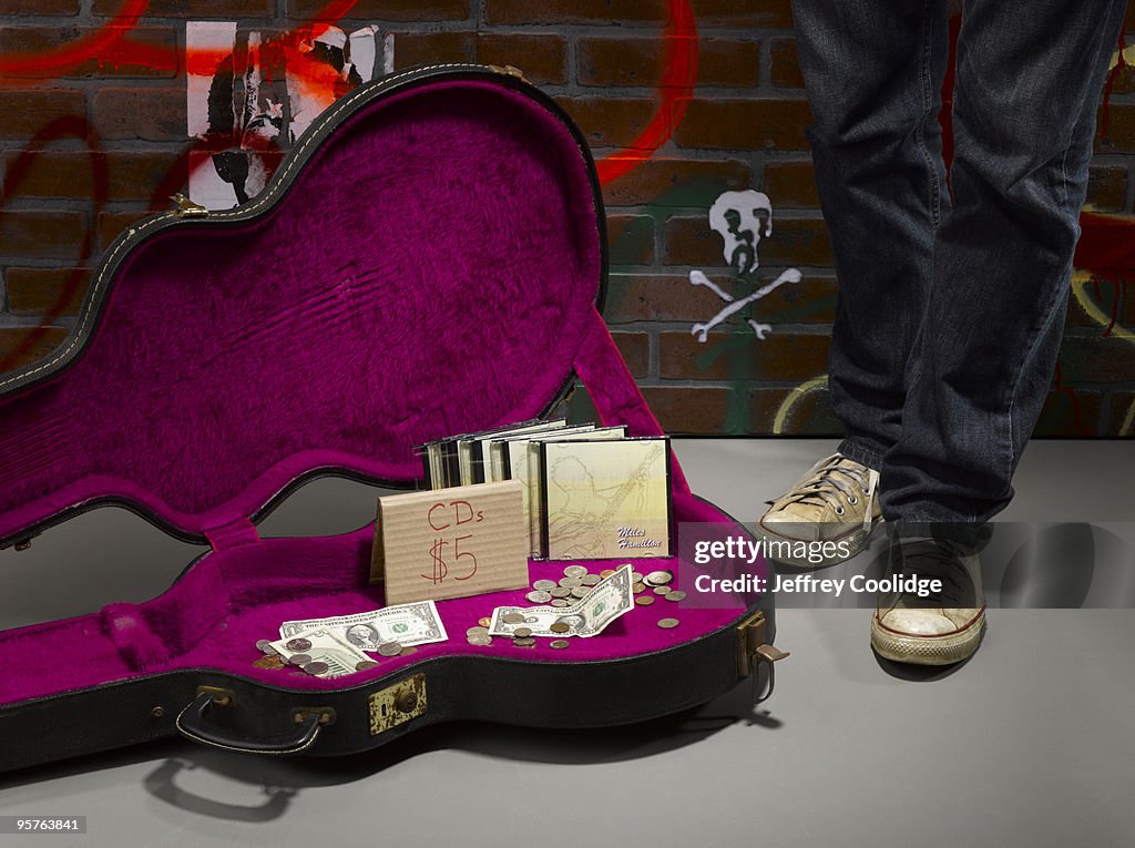 Guitar Case on Street with CDs For Sale