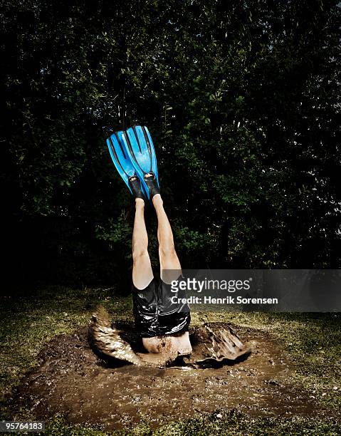 male diver with flippers dives into mud hole - quicksand stock pictures, royalty-free photos & images