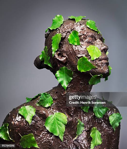 woman covered in wet mud and green leaves - people covered in mud stock pictures, royalty-free photos & images