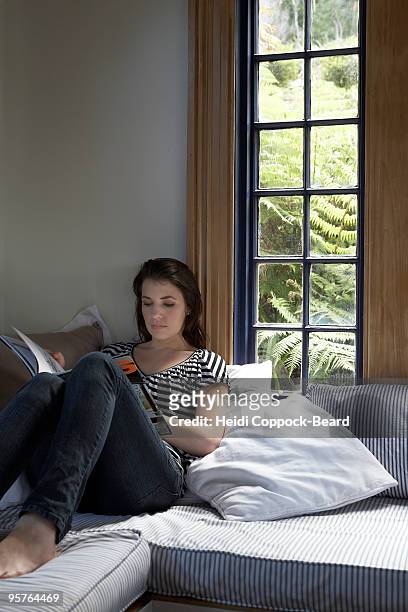 young woman reading magazine - heidi coppock beard 個照片及圖片檔