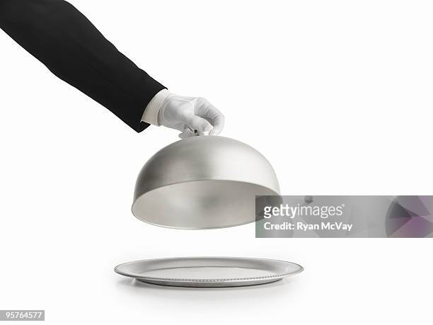 gloved hand lifting silver lid off a platter - bandeja fotografías e imágenes de stock