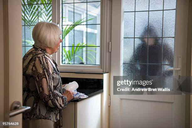 stranger at the door worrying an elderly woman - individu étrange photos et images de collection