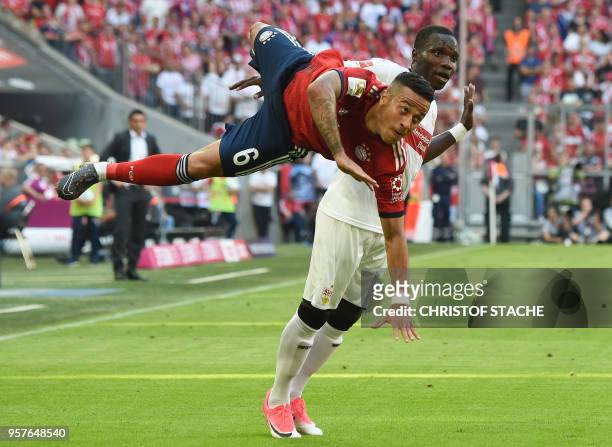 Bayern Munich's Spanish midfielder Thiago Alcantara falls against Stuttgart's Belgian midfielder Orel Mangala during the German first division...