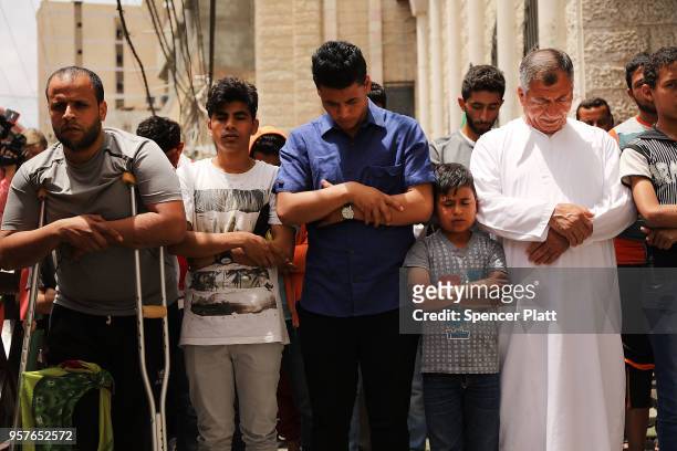 Men pray as the body of Jabir Abu Mustafa is brought out of a mosque for his funeral on May 12, 2018 in Khan Yunis, Gaza. Mustafa , who had five...