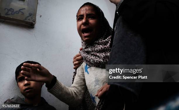 Daughter cries as the body of her father Jabir Abu Mustafa is brought outside of a mosque through the streets of Khan Yunis during his funeral on May...