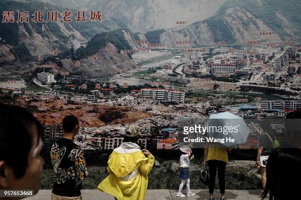 Visitor look at an image of the earthquake disaster at the ruins of earthquake-hit Beichuan county during the ten year anniversary on May 12, 2018 in...