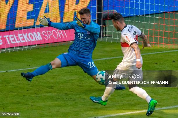 Stuttgart's German forward Daniel Ginczek shoots to score his team's fourth goal in front of Bayern Munich's German goalkeeper Sven Ulreich during...