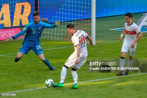 Stuttgart's German forward Daniel Ginczek shoots to score his team's fourth goal in front of Bayern Munich's German goalkeeper Sven Ulreich during...