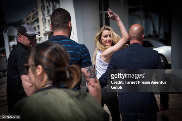 Amber Heard waves on her way to Hotel Martinez during the 71st annual Cannes Film Festival at on May 12, 2018 in Cannes, France.