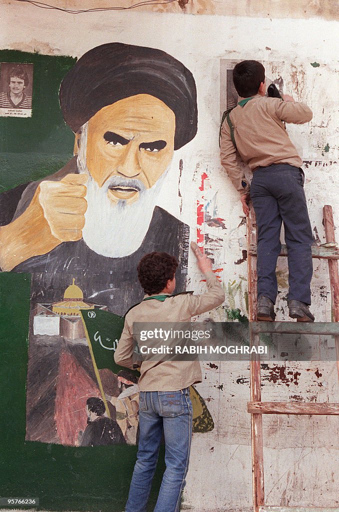 Young Lebanese scouts erase a portrait o