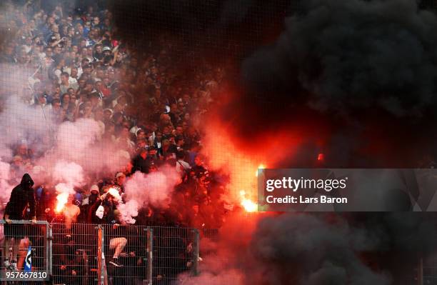 Fans set off flares during the Bundesliga match between Hamburger SV and Borussia Moenchengladbach at Volksparkstadion on May 12, 2018 in Hamburg,...