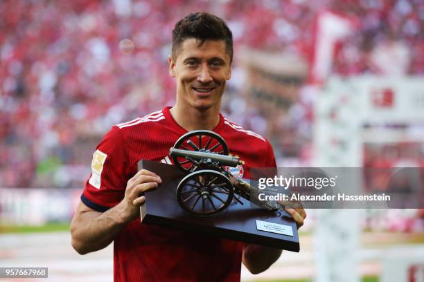 Robert Lewandowski of Bayern Muenchen celebrates with the award for top goal scorer in the Bundesliga during the Bundesliga match between FC Bayern...