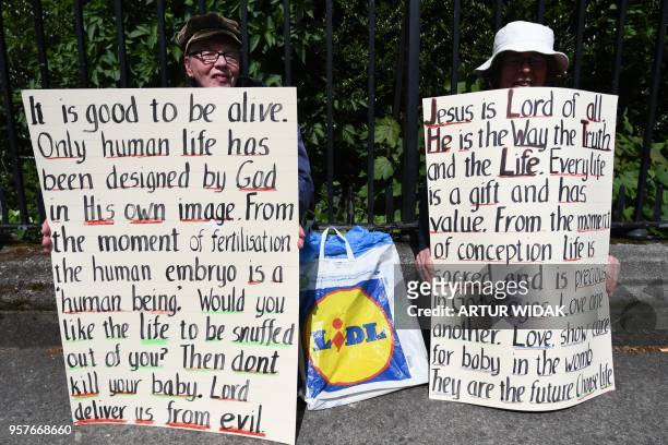 Pro-life activists hold up anti-abortion religious messages on placards during a "Stand up for Life" rally calling for a 'no' vote in the upcoming...