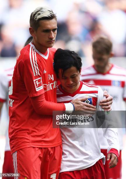 Julian Pollersbeck of Hamburger SV consoles Tatsuya Ito of Hamburger SV as their side are relegated after the Bundesliga match between Hamburger SV...