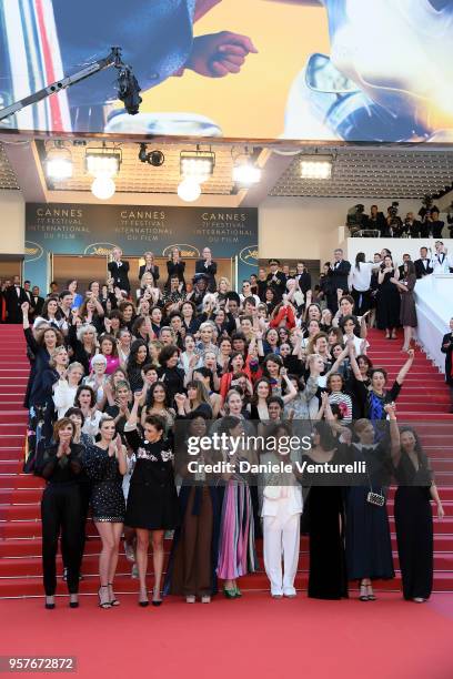 Filmmakers raise their arms as clap after Jury head Cate Blanchett with other filmmakers read a statement on the steps of the red carpet in protest...