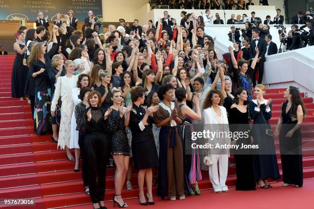 Filmmakers raise their arms as clap after Jury head Cate Blanchett with other filmmakers read a statement on the steps of the red carpet in protest...