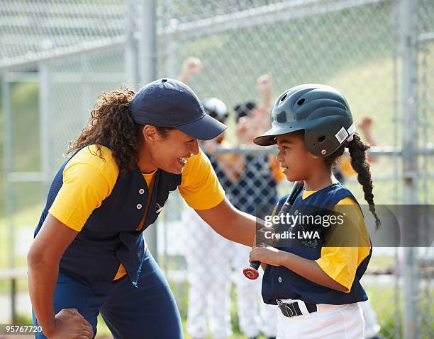coach helping little league batter - girl baseball cap stock pictures, royalty-free photos & images