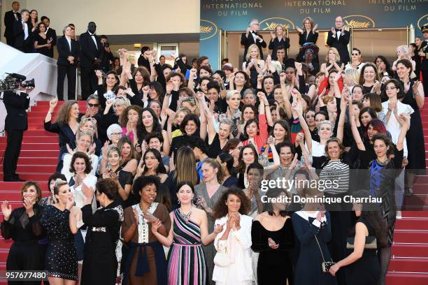 Filmmakers raise their arms as clap after Jury head Cate Blanchett with other filmmakers read a statement on the steps of the red carpet in protest...