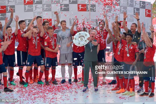 Bayern Munich's German head coach Jupp Heynckes lifts the trophy during the celebration for the 28th German football championship after the German...