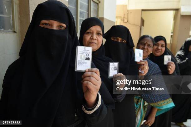 People stand in a polling booth to cast their votes during the Karnataka assembly election, on May 12, 2018in Bengaluru, India. The polling which...