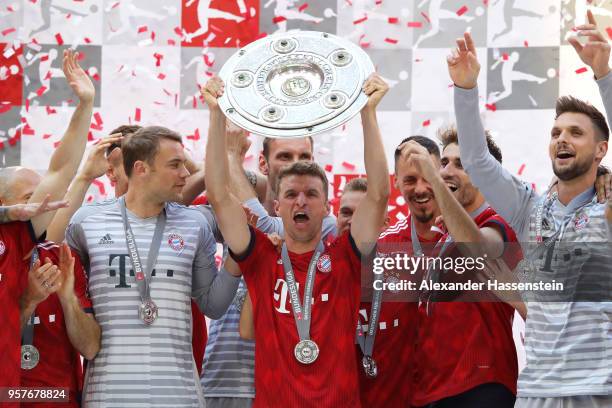 Thomas Mueller of Bayern Muenchen lifts the Bundesliga trophy following the Bundesliga match between FC Bayern Muenchen and VfB Stuttgart at Allianz...