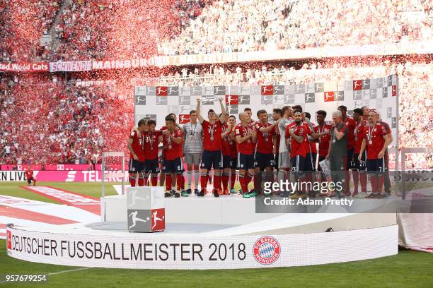 Robert Lewandowski of Bayern Muenchen lifts the Bundesliga champions trophy amidst his team after the Bundesliga match between FC Bayern Muenchen and...