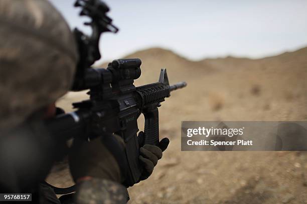 Sgt. Anthony McGee from Arizona and part of a Provincial Reconstruction Team looks through a rifle scope during a patrol in an area prone to ambushes...