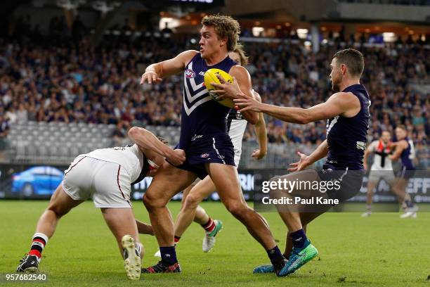 Mitchell Crowden of the Dockers looks to break from a tackle by Nick Coffield of the Saints during the round eight AFL match between the Fremantle...