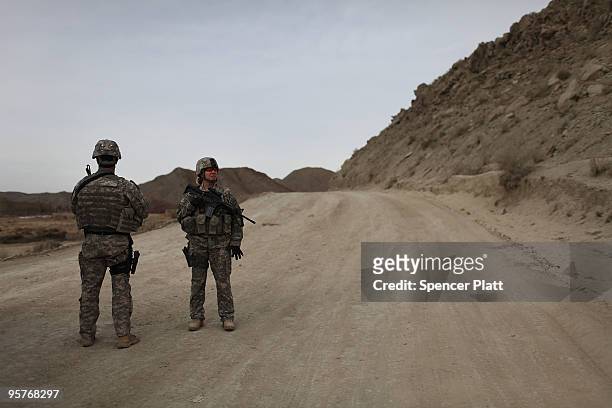 Members of a US Army Provincial Reconstruction Team stand on a road during a patrol in an area prone to ambushes January 14, 2010 in Alagehdari-ye...