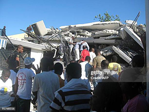 People look through destroyed buildings on January 13, 2010 in Port-au-Prince, Haiti. Planeloads of rescuers and relief supplies headed to Haiti...