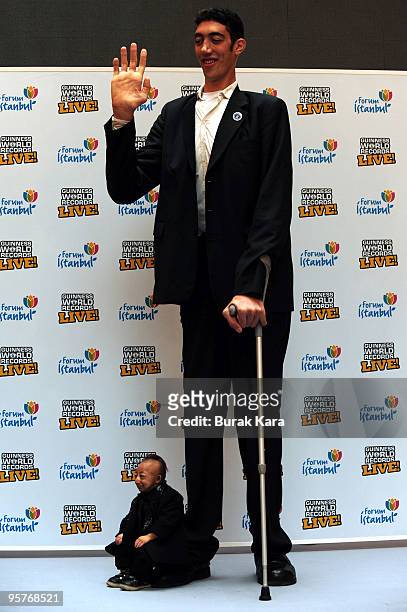 He Pingping of China sits on the foot of Sultan Kosen of Turkey as they attend the Guiness World Records Live! Roadshow, on January 14, 2010 in...