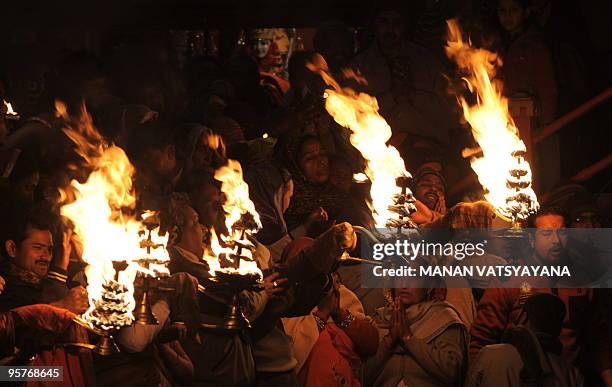 Indian Hindu priests perform evening prayers on the banks of the river Ganges on Makar Sankranti, one of the Kumbh Mela festival's main bathing days,...