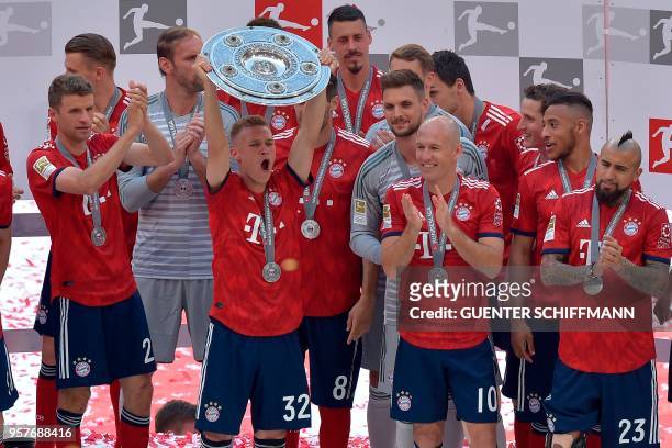 Bayern Munich's German midfielder Joshua Kimmich lifts the trophy at the end of the German first division Bundesliga football match FC Bayern Munich...
