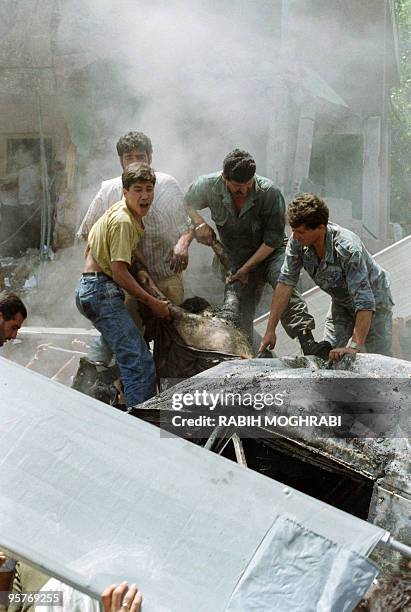 Rescuers remove 16 May1989 a body fo a victim killed by a car bomb explosion in a Moslem Aicha Bakkar quarter of Moslem west Beirut. At least 15...