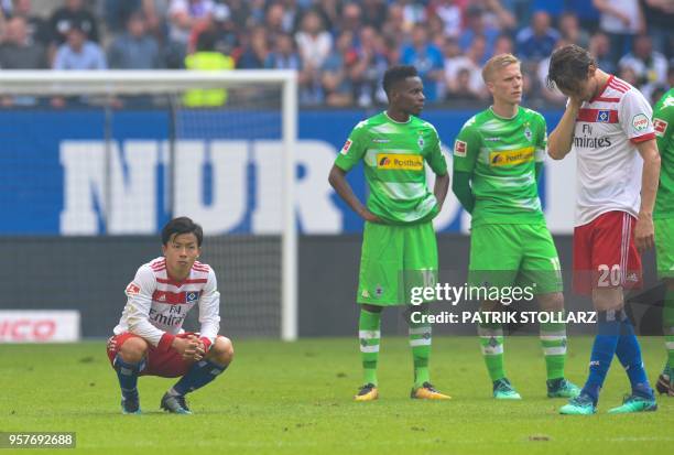 Players of Moenchengladbach and Hamburg wait on the pitch after Hamburg supporters throw fireworks during the German first division Bundesliga...