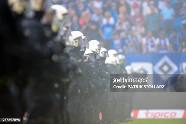 Policemen stand on the pitch after Hamburg supporters throw fireworks during the German first division Bundesliga football match Hamburger SV vs...