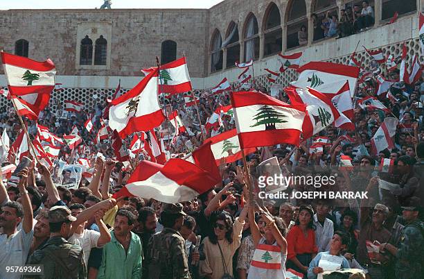 Christian Lebanese people wave national flags and portraits of General Aoun while they stage a protest 04 November 1989 in front of Baabda...