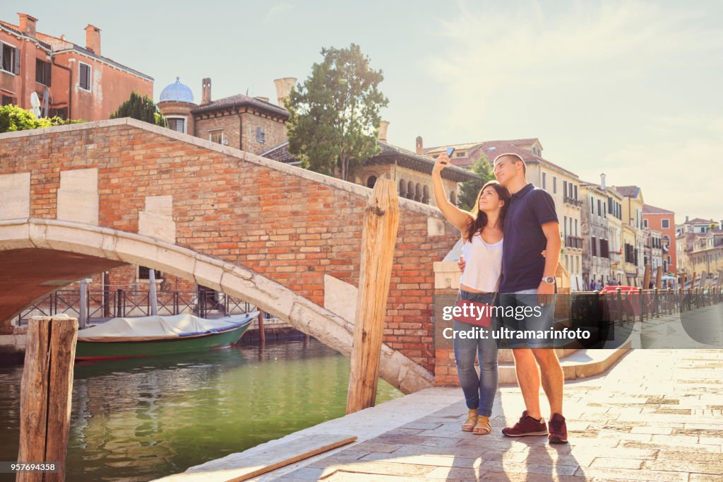 Touristen in Venezia. Junge Frauen und junge Männer, viel Spaß. Paar unter einem Selfie Phot mit Smartphone. Lässigen Lebensstil Städtisches Motiv Italien. Besuch in Venedig, Italien.
