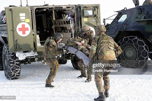 In this handout image members of the medical service of the Bundeswehr prepare during a miltary exercise for the visit of German Defense Minister...