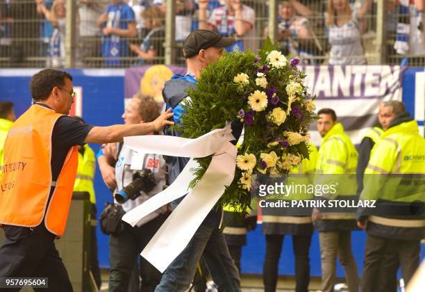 Hamburg supporter carries a wreath on the pitch after the German first division Bundesliga football match Hamburger SV vs Borussia Moenchengladbach...