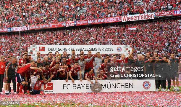 Bayern Munich's players pose with their trophy after their victory at the end of the German first division Bundesliga football match FC Bayern Munich...